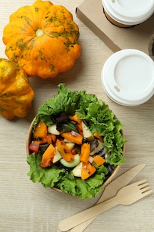 Concept of healthy food with pumpkin salad on wooden background