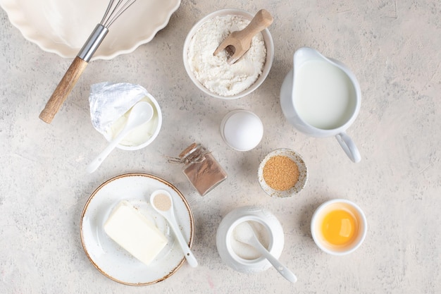 明るい背景に生地ケーキ カップケーキ卵小麦粉バター シナモン ミルク シュガーを作るためのホーム ベーキング材料の概念