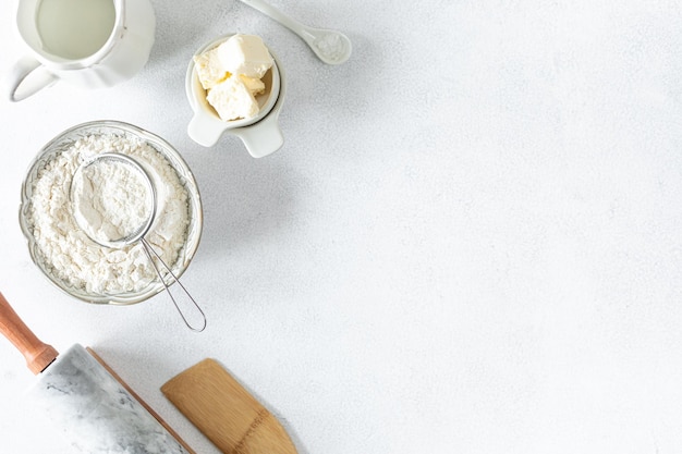 自家製ベーキングのコンセプトは、白い背景に大理石の麺棒小麦粉バターミルクです。コピースペース上面図ベーキングコンセプトフラットレイ