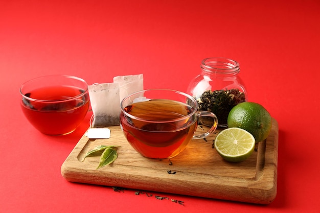 Concept of hot drink with tea on red background