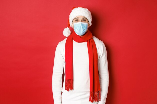 Concept of new year coronavirus and holidays cheerful man celebrating christmas and social distancin...