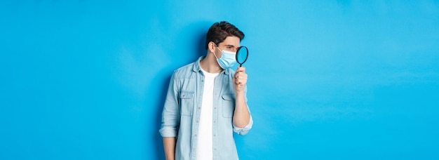 Бесплатное фото Концепция социального дистанцирования коронавируса и пандемического человека в медицинской маске, ищущего что-то ло