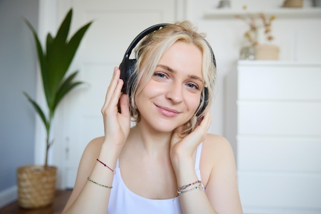 Free photo concept of people and lifestyle close up of beautiful blond woman in wireless headphones listens to