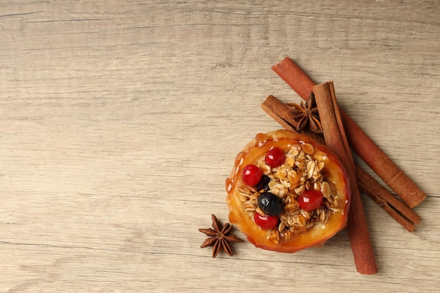 Concept of tasty food with baked apple on wooden background