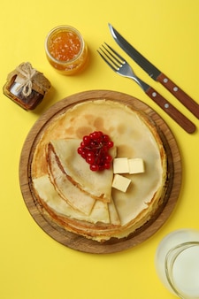 Concept of tasty food with crepes on yellow background