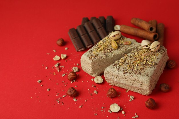 Concept of tasty food with halva on red background