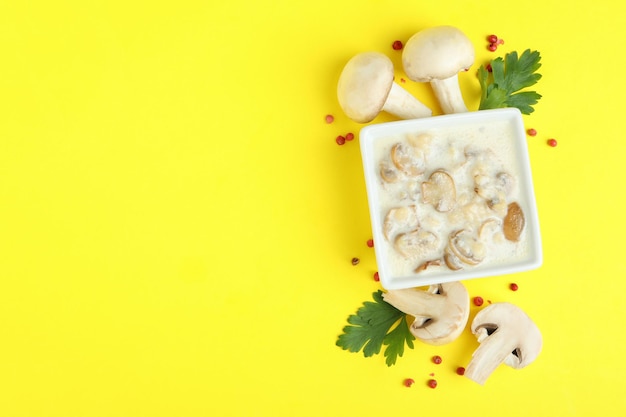 Concept of tasty food with mushroom sauce on yellow background