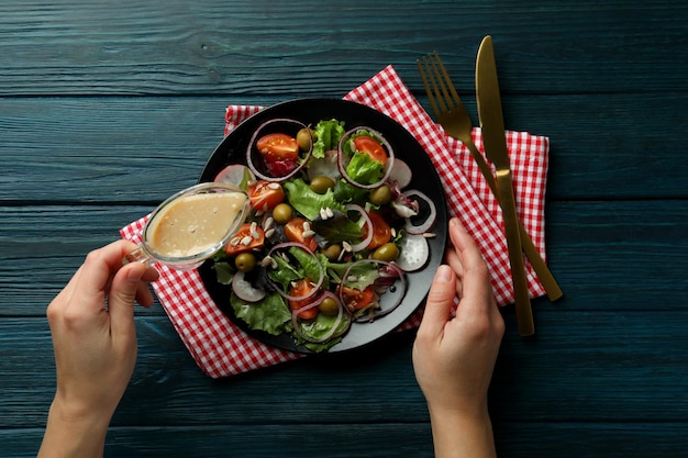 Concept of tasty food with vegetable salad with tahini sauce on wooden background
