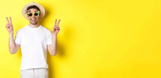 Free photo concept of tourism and lifestyle happy man enjoying trip wearing summer hat and sunglasses posing wi