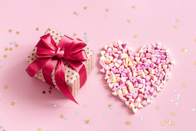 The concept of Valentine's day. Gift box with red bow on pink.