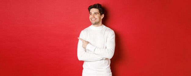 Concept of winter holidays christmas and lifestyle handsome adult man in white sweater looking and p...