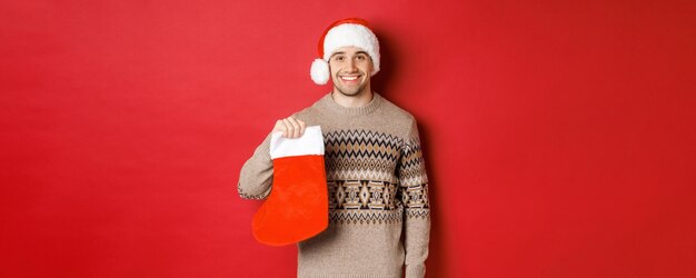 Concept of winter holidays new year and celebration image of handsome smiling man in santa hat and s