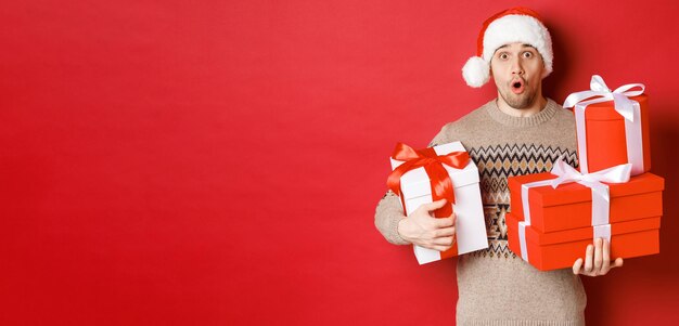 Concept of winter holidays new year and celebration image of surprised handsome guy in sweater and s...