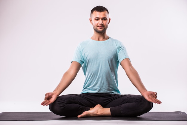 Concept of yoga. Handsome man doing yoga exercise isolated on a white background