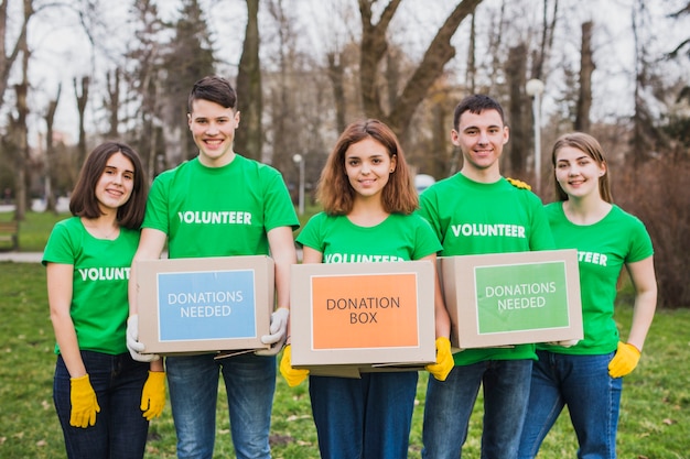 Concepto de medio ambiente y voluntariado con personas que sostienen cajas para donaciones