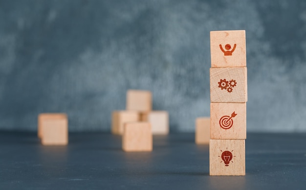 Conceptual of business with wooden blocks column with icons.