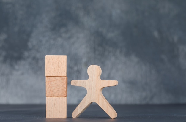 Conceptual of business with wooden blocks column with wooden human figure.