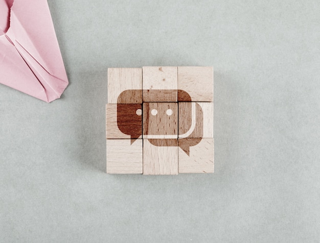 Conceptual of business with wooden blocks with message bobble icon top view.