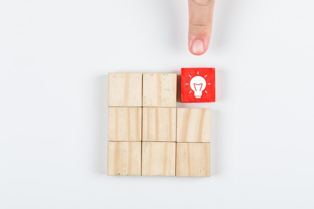 Conceptual of idea hand pointing the idea. with wooden blocks on white background top view. horizontal image