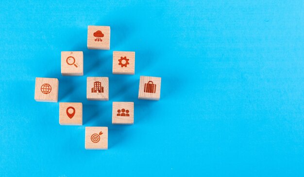 Conceptual of medical center with wooden blocks with icons on blue table flat lay.