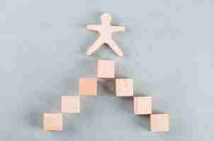 Free photo conceptual of success business with wooden human, rectangle blocks.