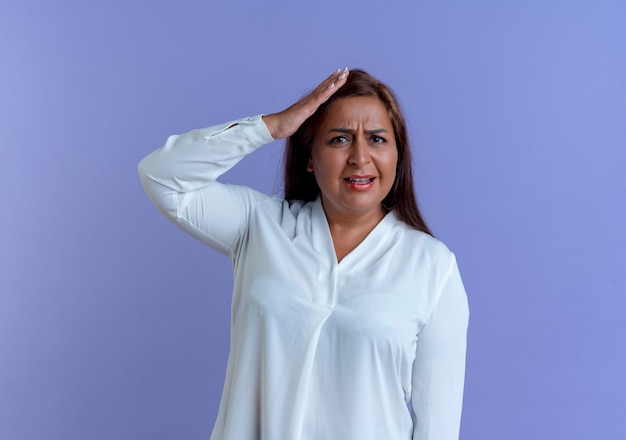 Concerned casual caucasian middle-aged woman putting hand on head 