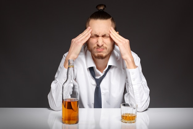 Free photo concerned employee with a bottle of whiskey