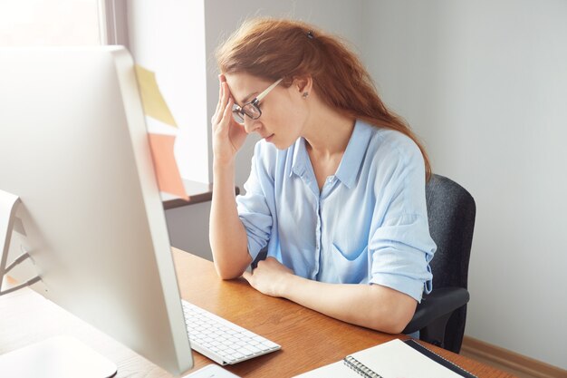 사무실에서 일하는 동안 컴퓨터 화면을보고 걱정되는 여성 기업가