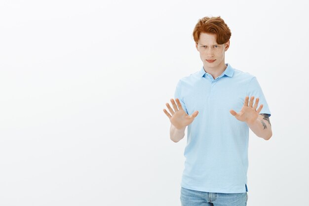 Concerned redhead man trying solve situation, calm down, raising hands up to resolve argument