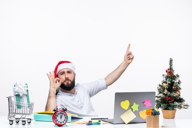 Giovane uomo d'affari interessato con il cappello di babbo natale che lavora al nuovo anno