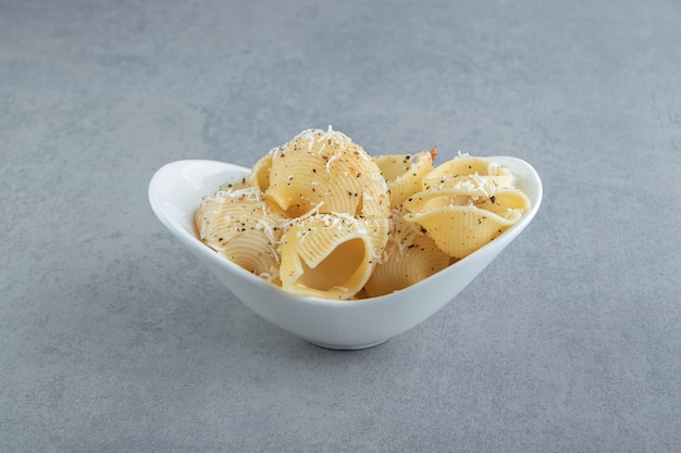 Free photo conchiglie pasta with spices in white bowl. high quality illustration