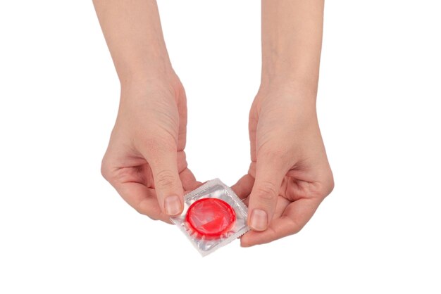 Condom in woman hand isolated on a white background.