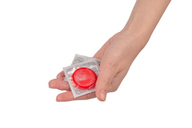 Condom in woman hand isolated on a white background.