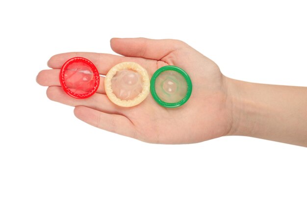 Condom in woman hand isolated on a white background.