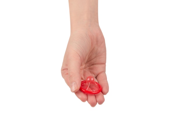 Condom in woman hand isolated on a white background.