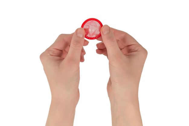 Condom in woman hand isolated on a white background.