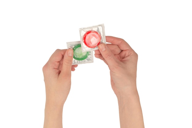 Condom in woman hand isolated on a white background.