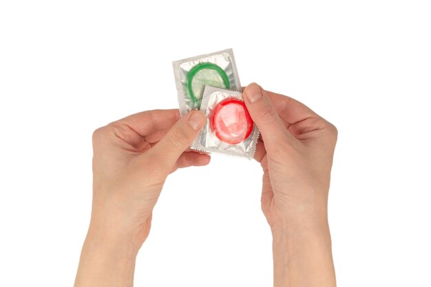 Condom in woman hand isolated on a white background.