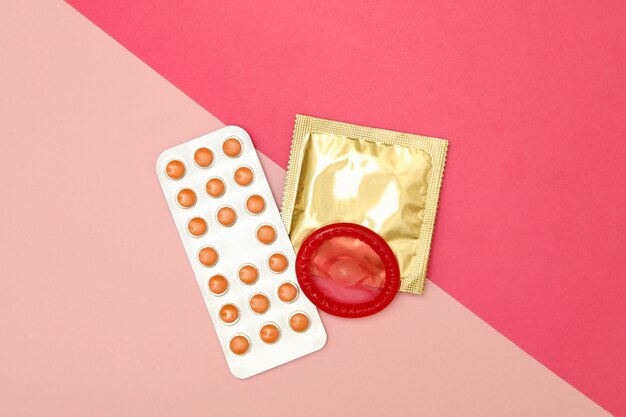 Condoms and pills on two tone surface