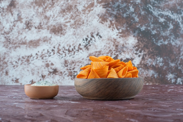 Chip di cono in una ciotola con yogurt in una ciotola sulla superficie di marmo