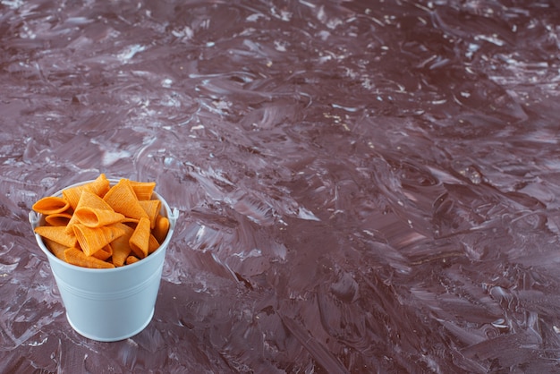 Foto gratuita chip di cono in un secchio, sul tavolo di marmo.