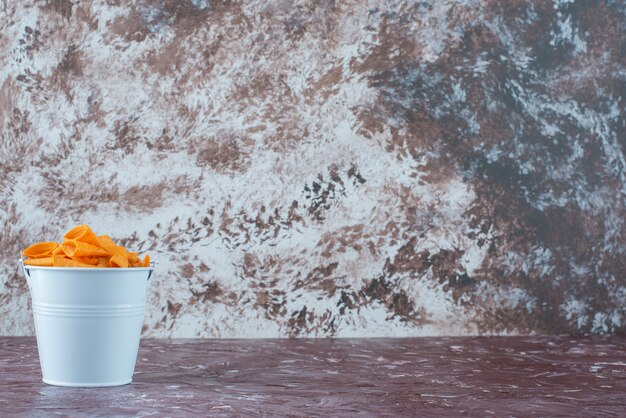 Foto gratuita chip di cono in un secchio, sul tavolo di marmo.