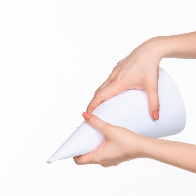The cone in female hands on white background