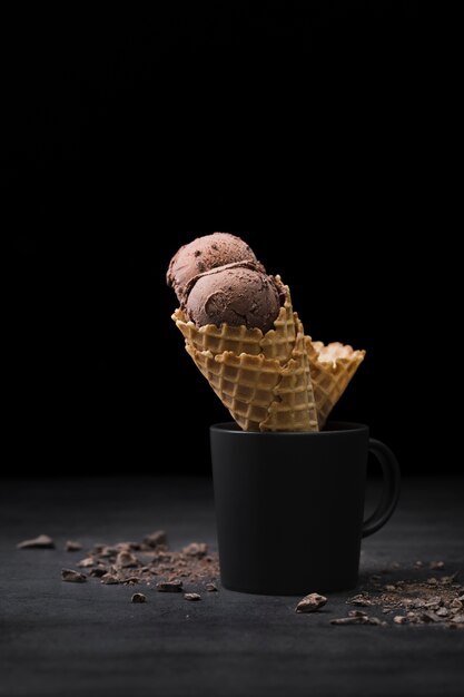 Cones with ice cream in cup on table