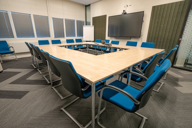 Foto gratuita interno della sala conferenze di un ufficio moderno con pareti bianche e un monitor