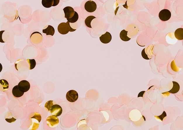 Бесплатное фото Конфетти на новогодней вечеринке с розовым фоном