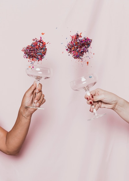 Confetti flying out of glasses at new years party