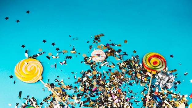 Free photo confetti and lollipops on blue background