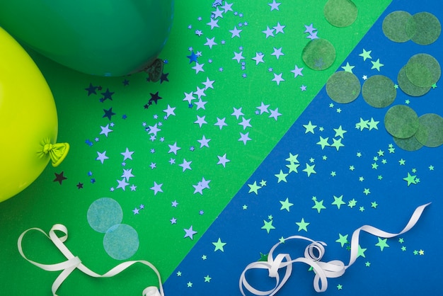 Confetti stars and balloons on colorful background