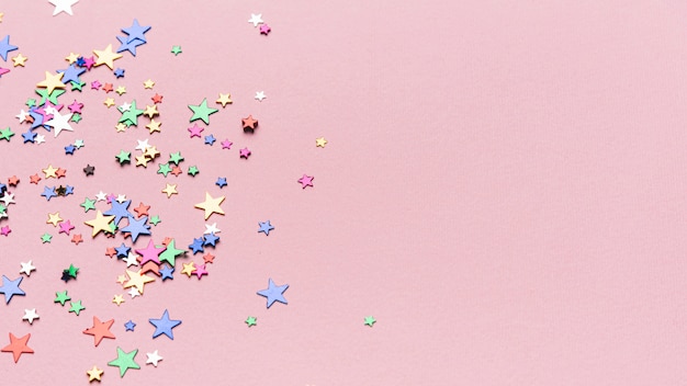 Confetti stars on pink background with copy space